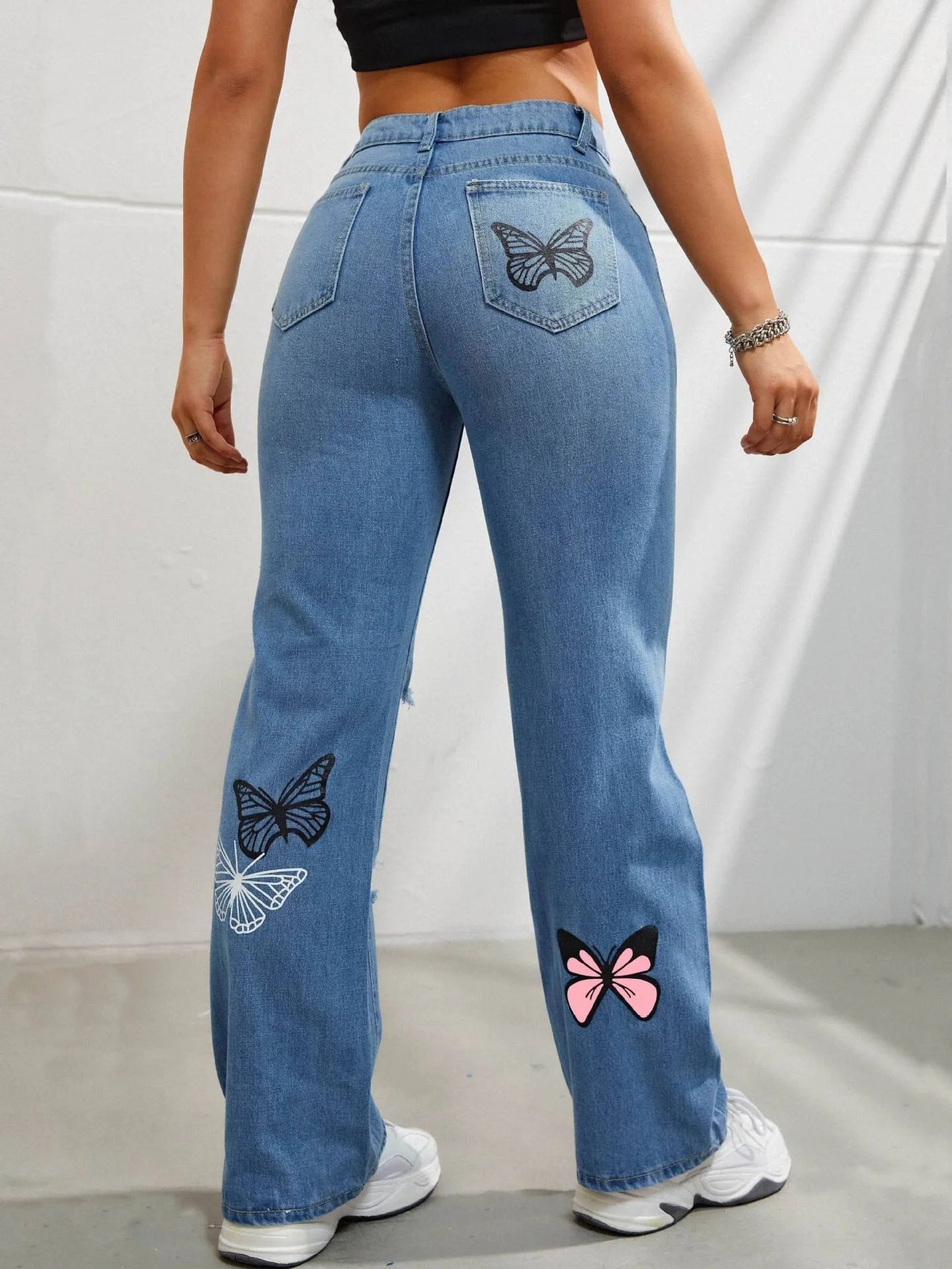 High-waisted straight leg jeans with trendy butterfly print, distressed detailing, and button closure for a stylish, flattering look.