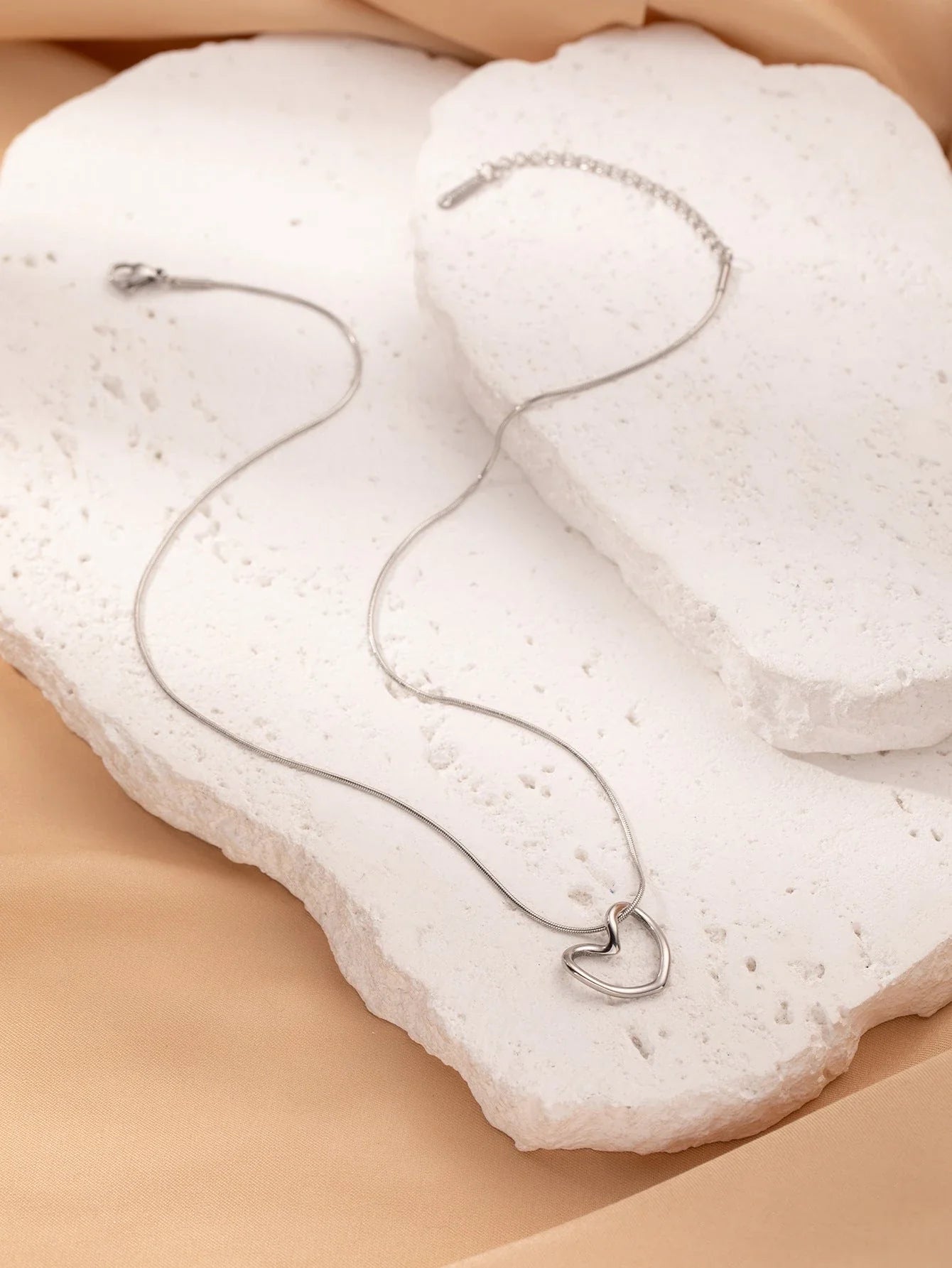 Titanium steel heart pendant necklace in gold and silver finishes, featuring an elegant and adjustable design for a customized fit