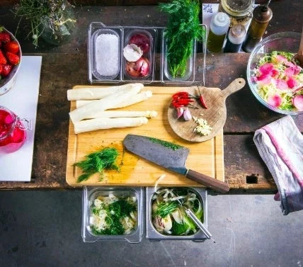Bamboo cutting board with plastic storage trays for organizing and containing chopped food items