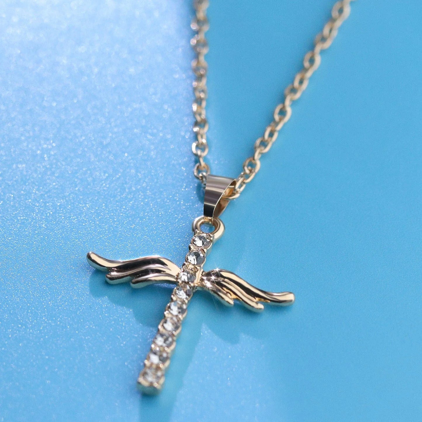 Elegant angel wings cross pendant necklace in silver and gold tones with an adjustable chain