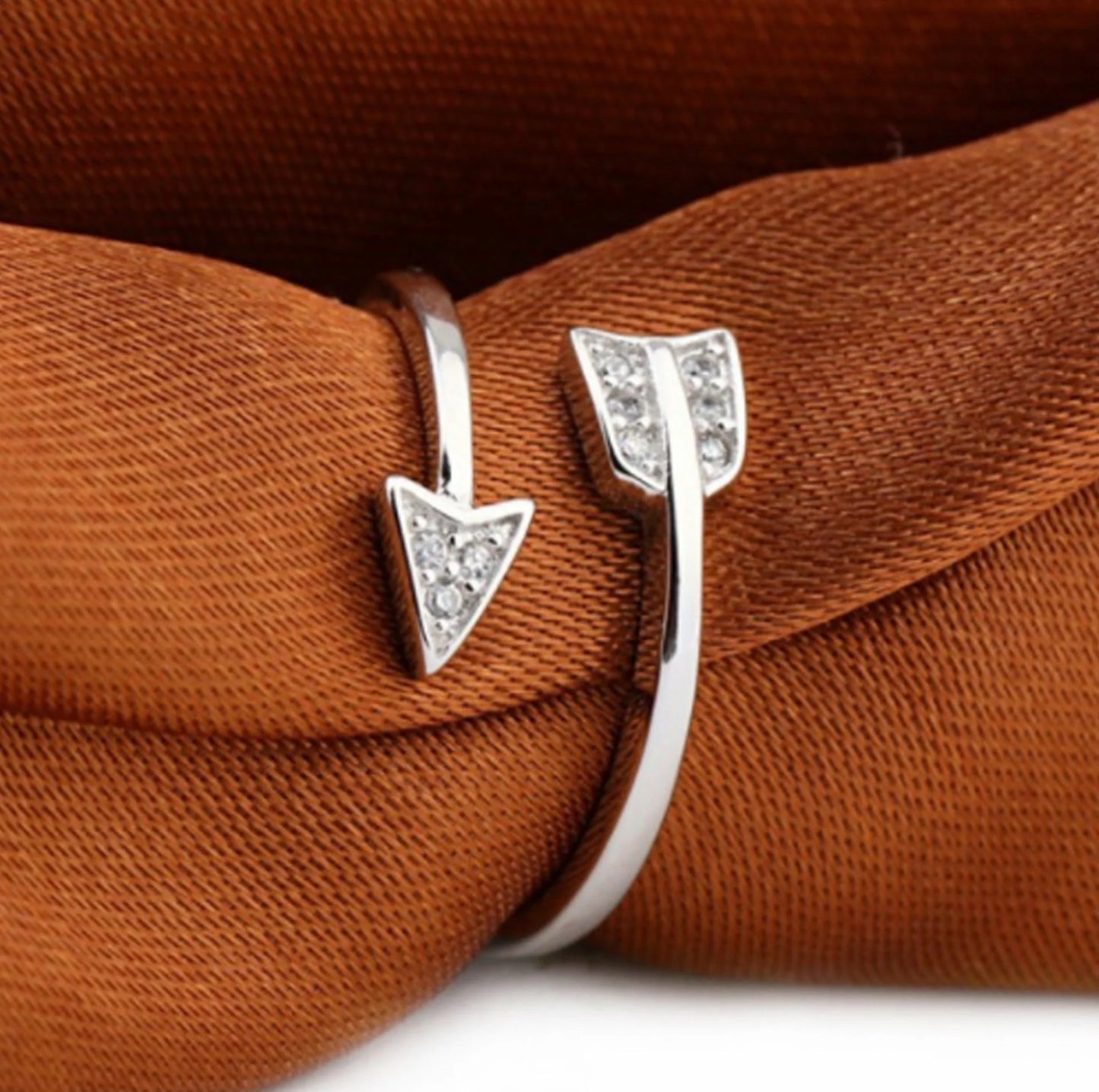 Copper arrow-shaped ring with a sleek, polished finish and a touch of subtle shimmer for a sophisticated, modern look.