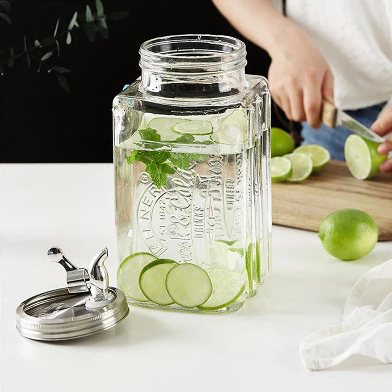 A stylish glass beverage dispenser with a sleek faucet, perfect for serving chilled drinks at home or events.
