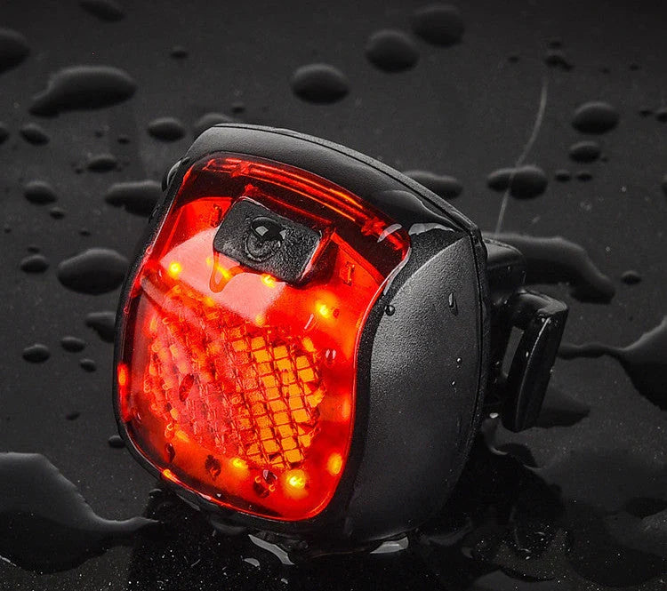 Rechargeable bicycle tail light with 5 adjustable lighting modes, made of durable ABS plastic for scratch and impact resistance.