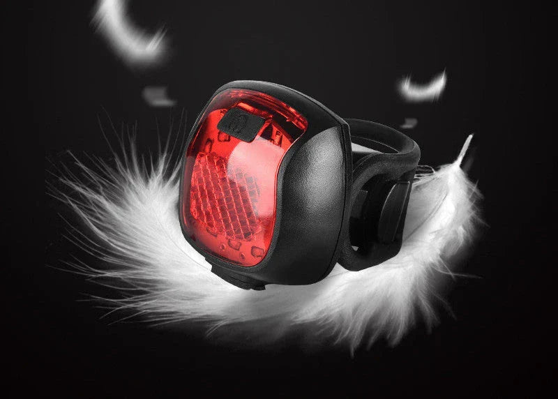Rechargeable bicycle tail light with 5 adjustable lighting modes, made of durable ABS plastic for scratch and impact resistance.