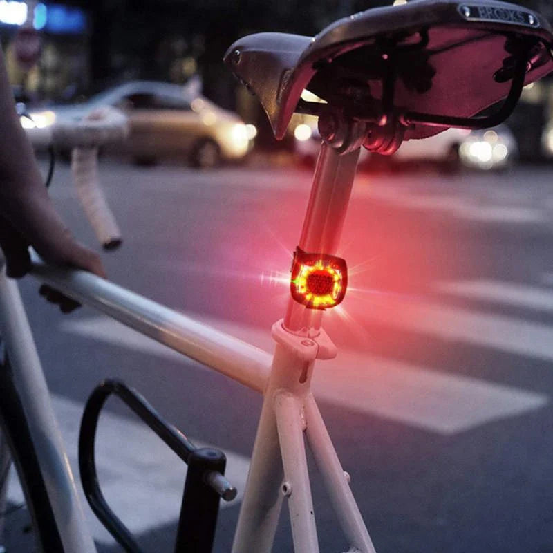 Rechargeable bicycle tail light with 5 adjustable lighting modes, made of durable ABS plastic for scratch and impact resistance.