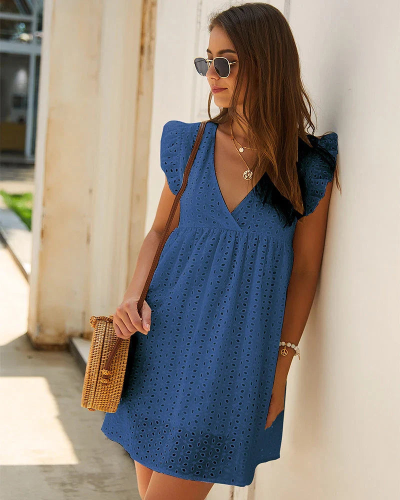 A stylish cotton mini dress with a v-neck and ruffled sleeves, perfect for summer days and nights.