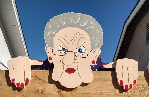 Quirky garden fence art decoration featuring an elderly couple peeking over a fence