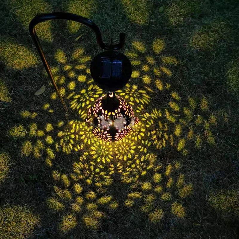 Solar-powered outdoor hanging lantern with flower-patterned shade, made of durable metal for long-lasting use in gardens, patios, and pathways.