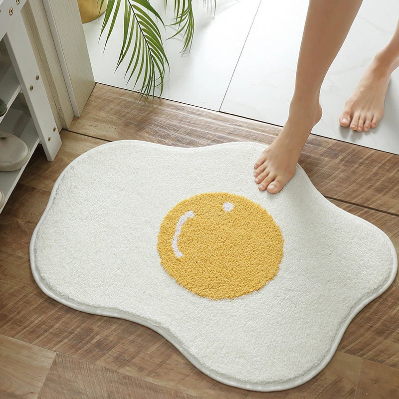 Quirky egg-shaped entrance mat made of absorbent polyester fabric with non-slip rubber backing, available in various sizes and colours