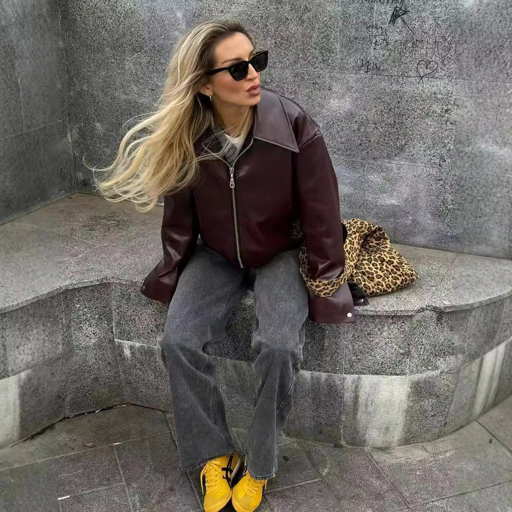 Fashionable faux leather jacket in burgundy and black colors, featuring a zipper closure and long sleeves for casual, versatile wear