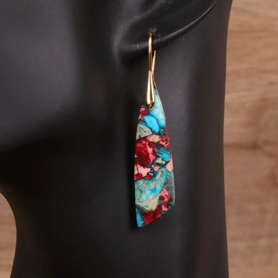 Geometric flower shape pendant earrings in copper with gold hooks, available in red, green, and blue.