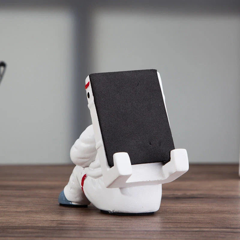 Charming astronaut-themed mobile phone stand made of high-quality resin, designed to securely hold your phone on your desk or workspace