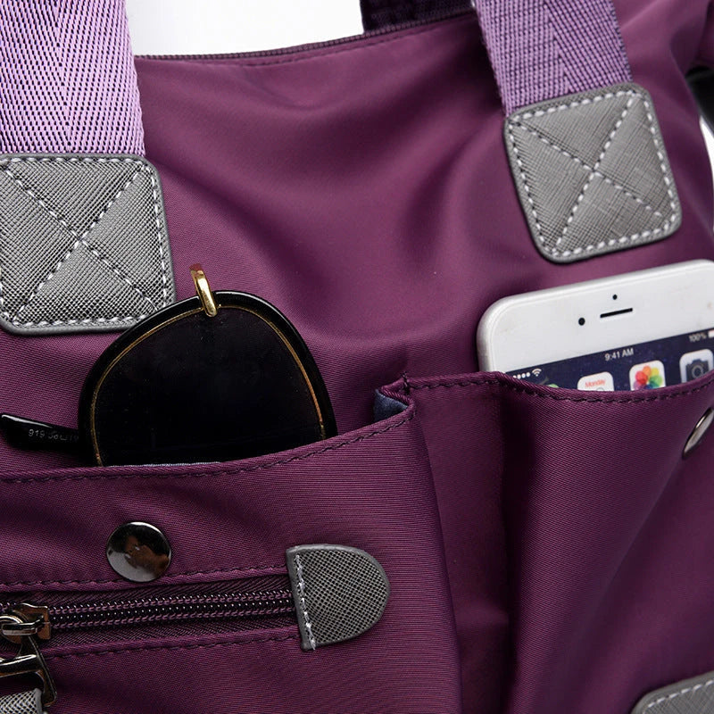 Versatile ladies shoulder bag with multiple carry options, numerous pockets, and durable Oxford fabric construction