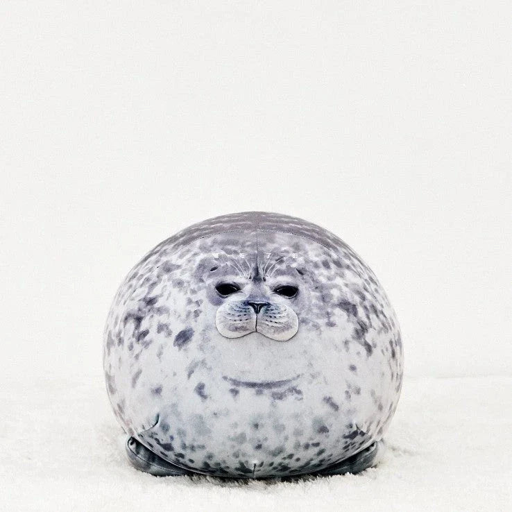 A plush, soft, and cuddly grey or white seal-shaped cushion with a detailed, lifelike design