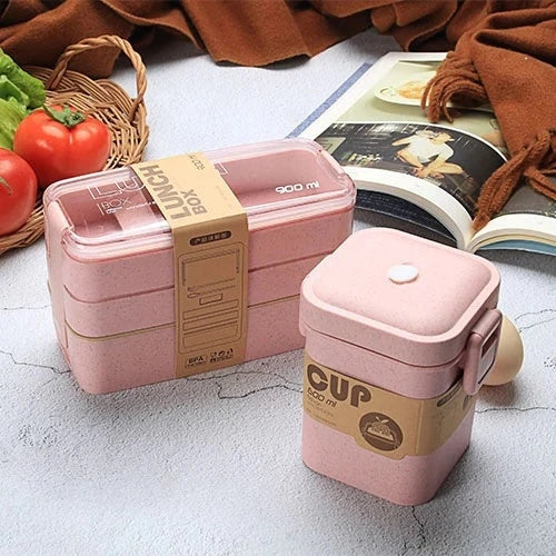 A stylish microwave-safe lunch box with a removable soup mug in various colours, including pink, green, and apricot