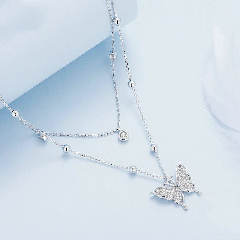 A stunning silver double-layer necklace with a captivating butterfly design and delicate fringed detailing