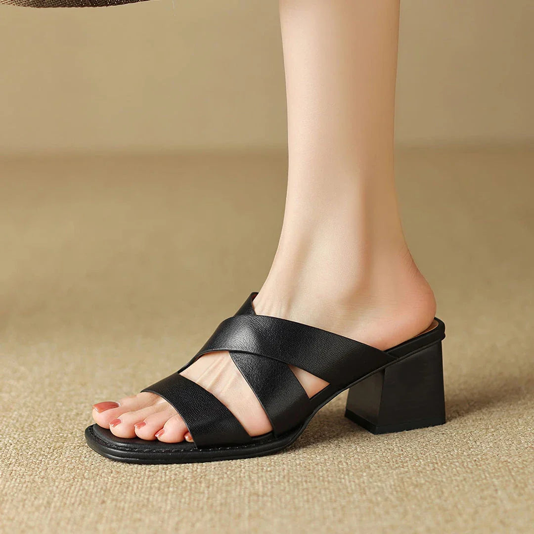 Black leather high-heel slippers with a stylish square heel, showcasing a sophisticated and comfortable design.