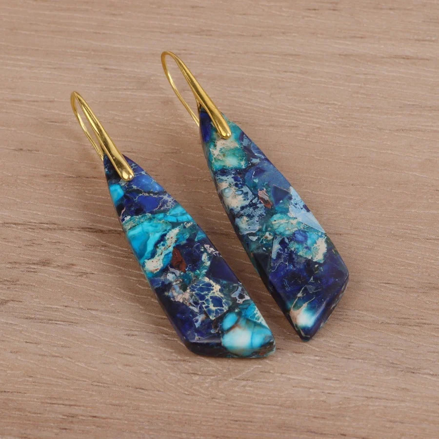 Geometric flower shape pendant earrings in copper with gold hooks, available in red, green, and blue.