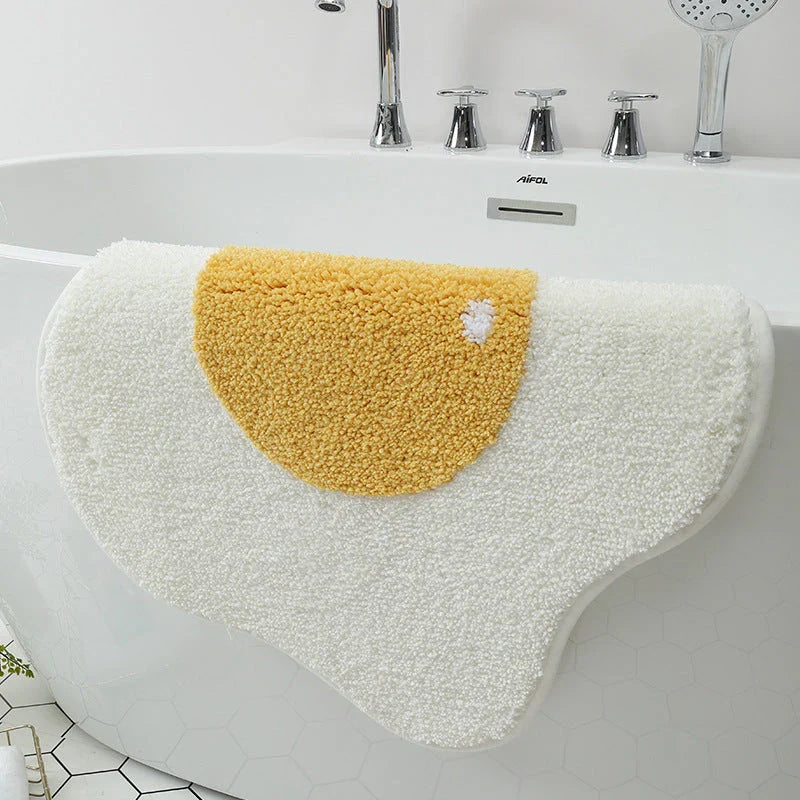 Quirky egg-shaped entrance mat made of absorbent polyester fabric with non-slip rubber backing, available in various sizes and colours