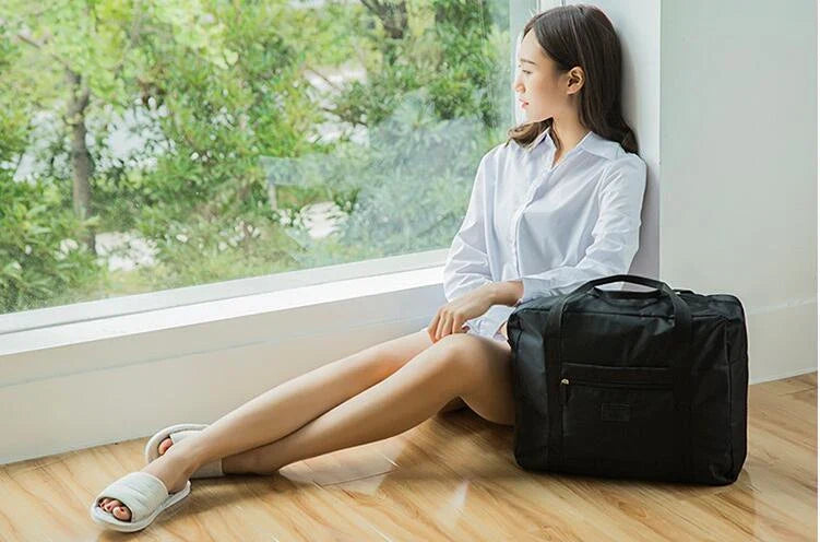 Foldable nylon travel holdall in various colours, including black, orange, green, and red