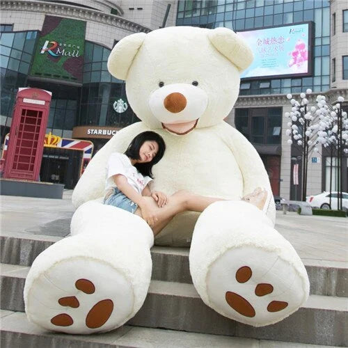 Colossal plush teddy bear in various sizes and colors, including light brown, dark brown, gray, white, pink, and purple