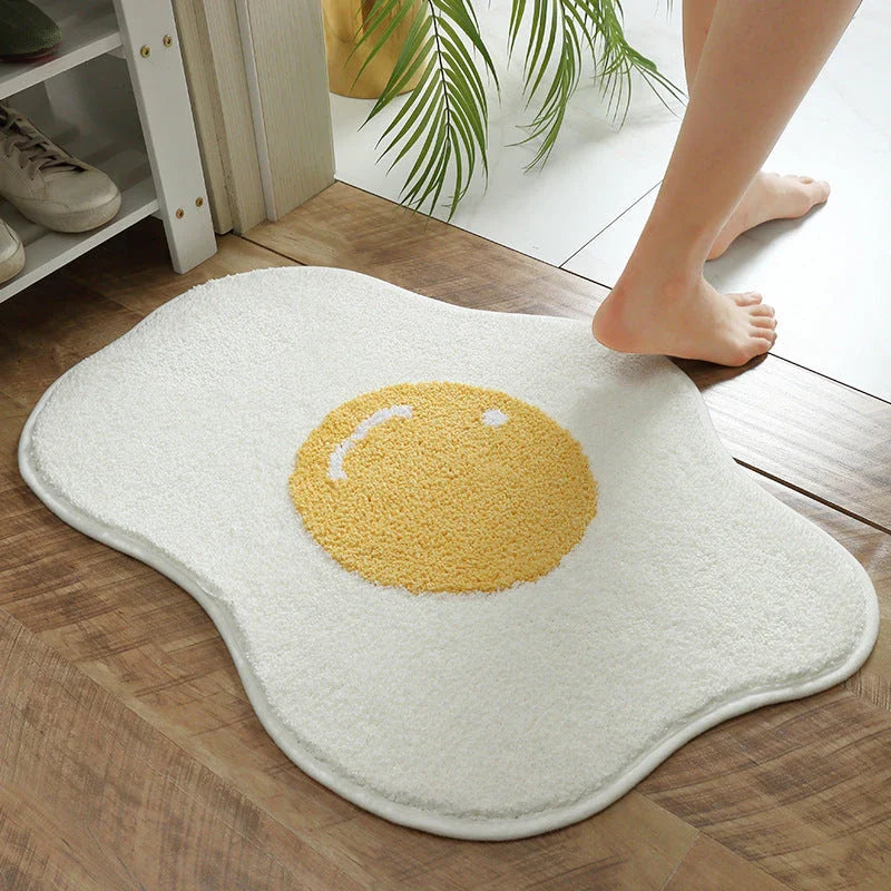 Quirky egg-shaped entrance mat made of absorbent polyester fabric with non-slip rubber backing, available in various sizes and colours