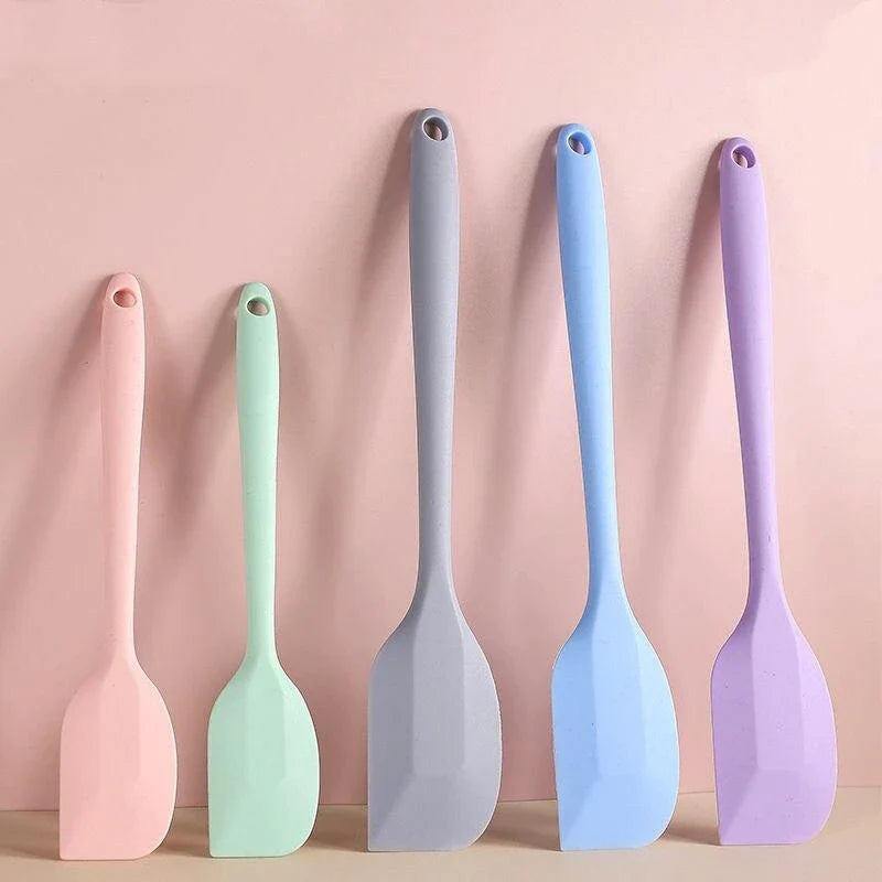 A vibrant red silicone baking spatula with an ergonomic handle and double-sided arc design, perfect for a variety of cooking and baking tasks.