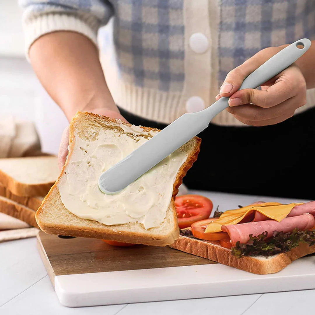 A vibrant red silicone baking spatula with an ergonomic handle and double-sided arc design, perfect for a variety of cooking and baking tasks.