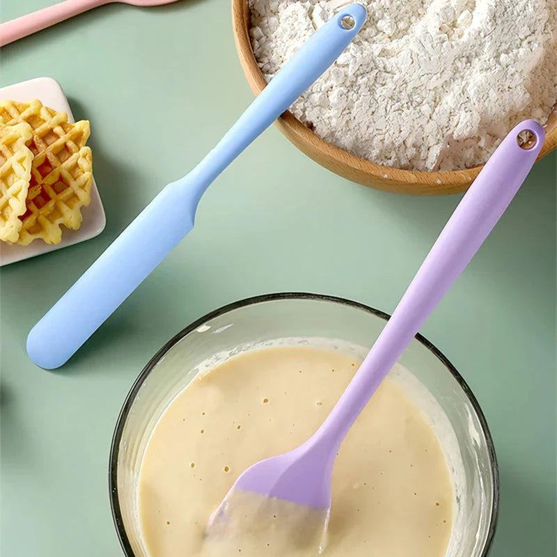A vibrant red silicone baking spatula with an ergonomic handle and double-sided arc design, perfect for a variety of cooking and baking tasks.
