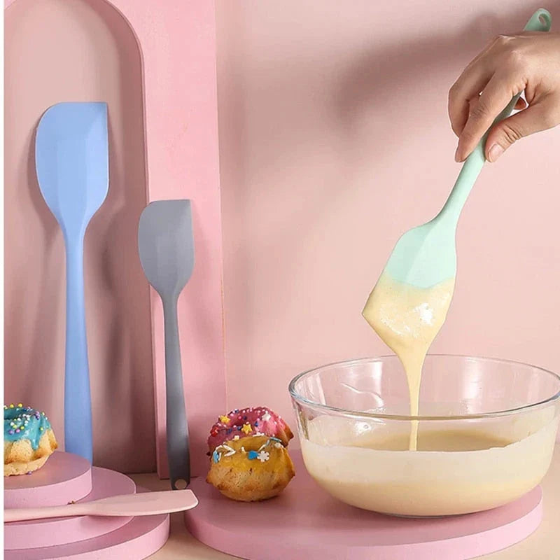 A vibrant red silicone baking spatula with an ergonomic handle and double-sided arc design, perfect for a variety of cooking and baking tasks.