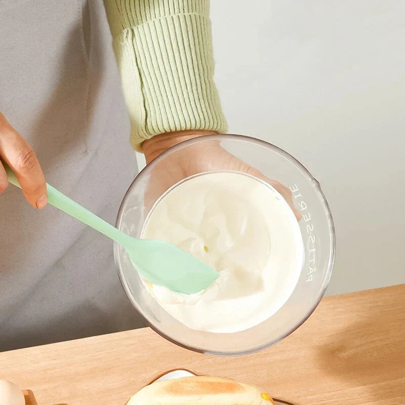 A vibrant red silicone baking spatula with an ergonomic handle and double-sided arc design, perfect for a variety of cooking and baking tasks.