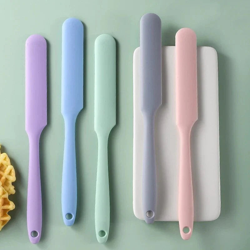 A vibrant red silicone baking spatula with an ergonomic handle and double-sided arc design, perfect for a variety of cooking and baking tasks.