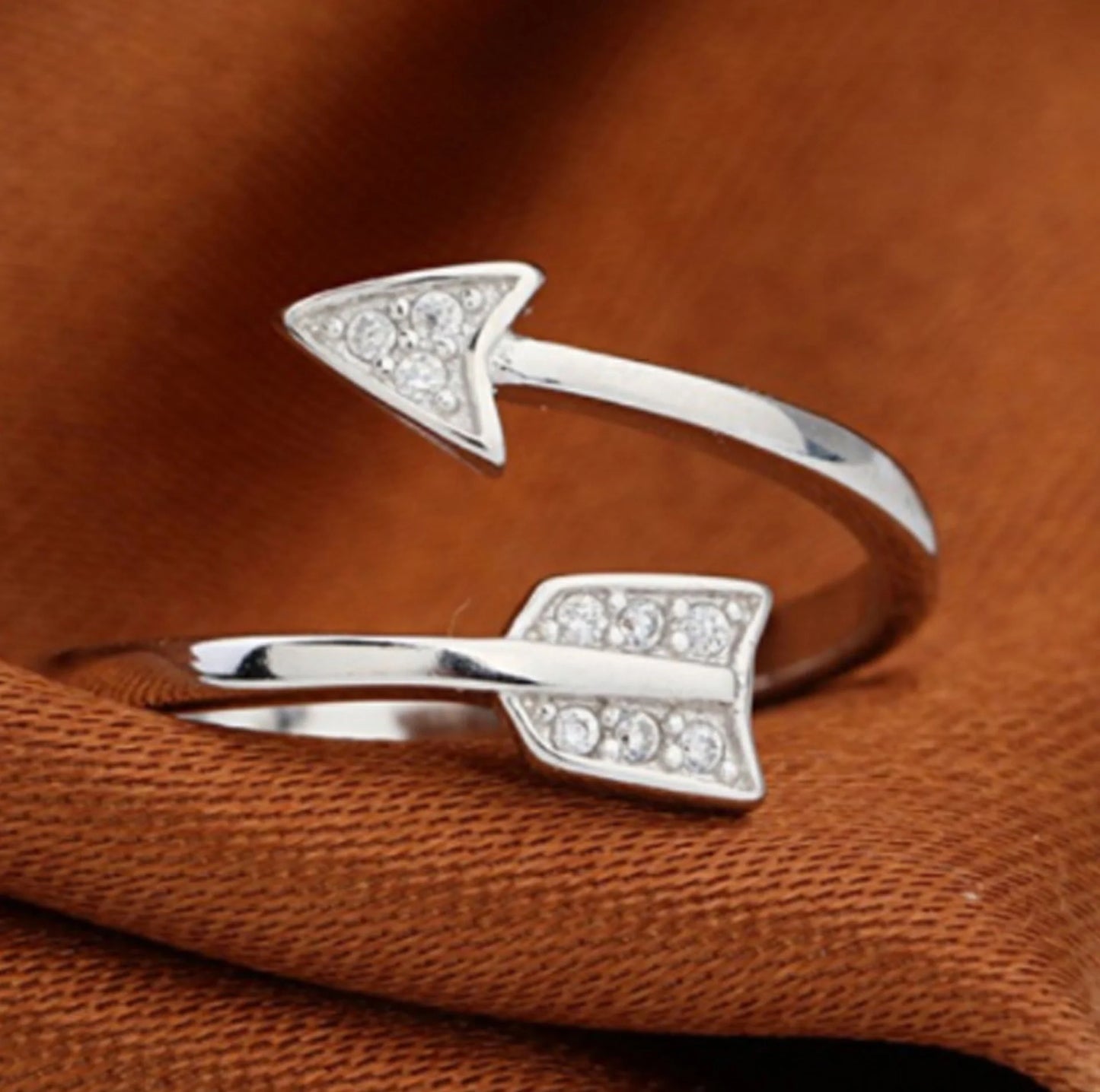 Copper arrow-shaped ring with a sleek, polished finish and a touch of subtle shimmer for a sophisticated, modern look.