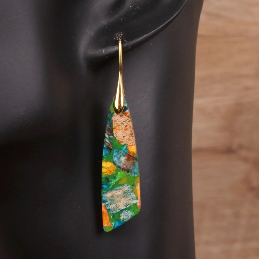 Geometric flower shape pendant earrings in copper with gold hooks, available in red, green, and blue.