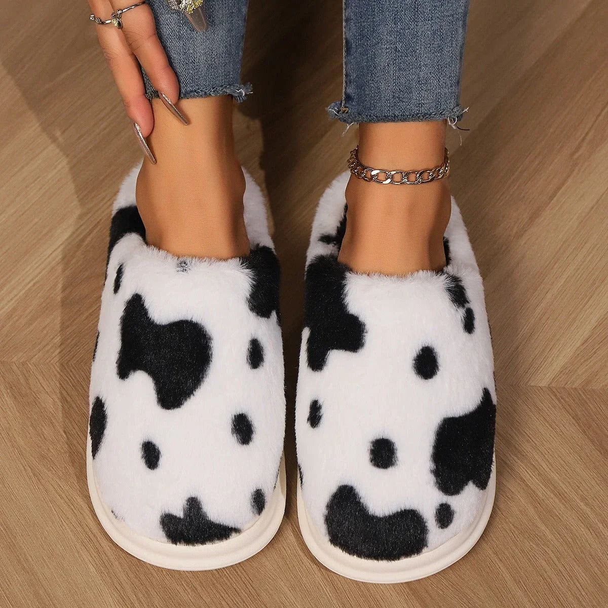 Cozy cow print plush slippers with a non-slip sole, perfect for indoor comfort and warmth