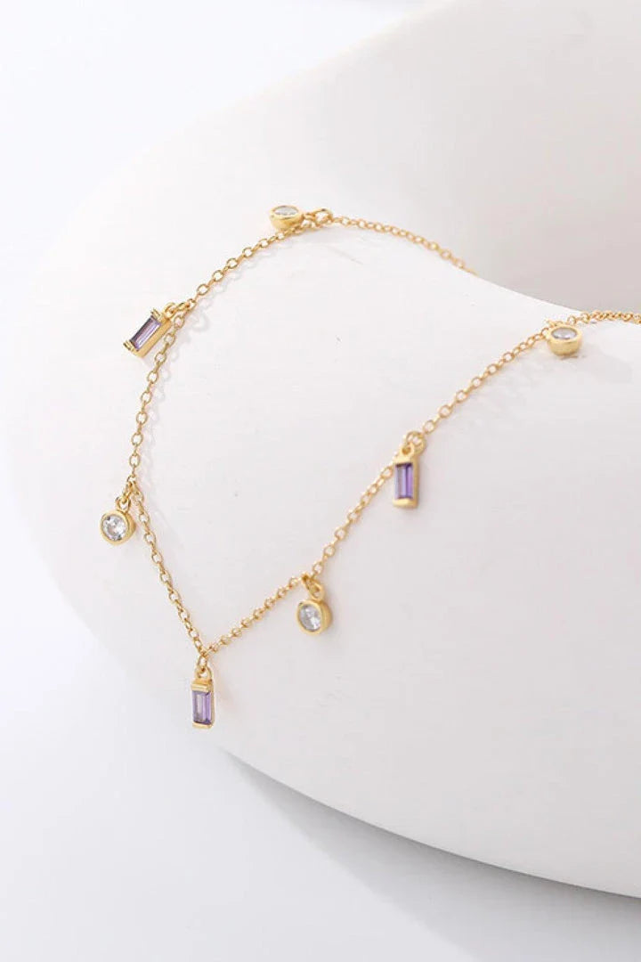 Elegant 18K gold-plated multi-charm chain necklace with delicate charms and a minimalist design