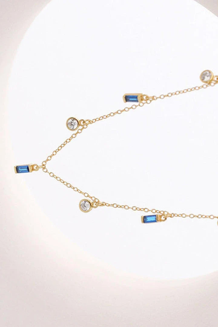 Elegant 18K gold-plated multi-charm chain necklace with delicate charms and a minimalist design