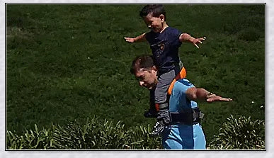 A parent carrying their child hands-free using the Hands-Free Shoulder Carrier, a versatile and comfortable child-carrying accessory.