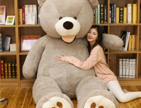 Colossal plush teddy bear in various sizes and colors, including light brown, dark brown, gray, white, pink, and purple