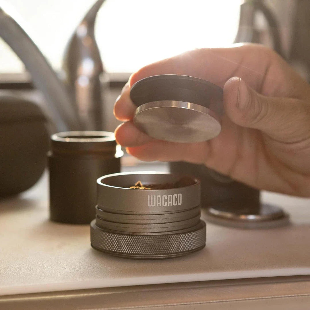 Portable espresso maker with a sleek black design, featuring a naked portafilter and manual operation for crafting premium coffee on the go.