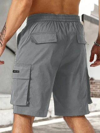 Drawstring waist men's multi-pocket workwear shorts in various colours, designed for comfort and functionality on the job site or for DIY projects.