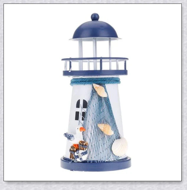 Oceanica LED Lighthouse Lantern Nightlight with nautical details like a small boat, life buoy, and seashells, providing a soft warm glow.