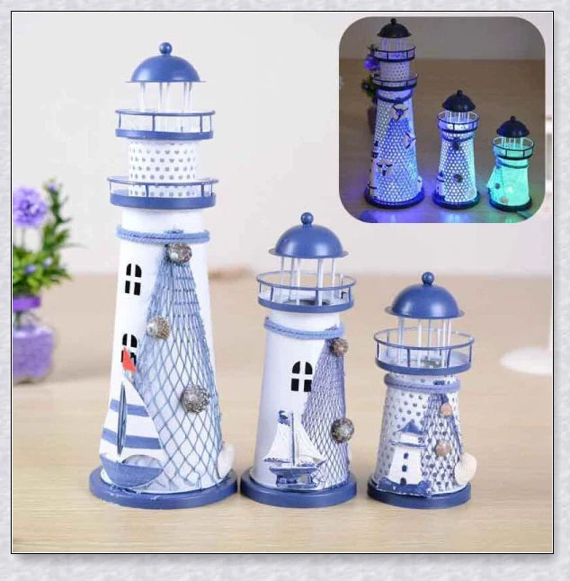 Oceanica LED Lighthouse Lantern Nightlight with nautical details like a small boat, life buoy, and seashells, providing a soft warm glow.