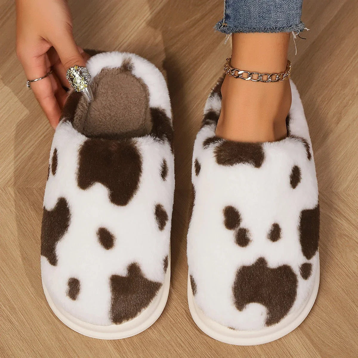 Cozy cow print plush slippers with a non-slip sole, perfect for indoor comfort and warmth