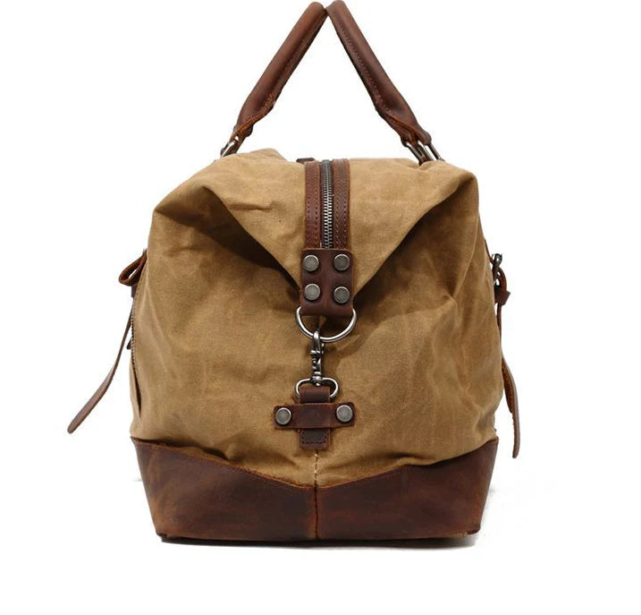 A large, khaki-coloured canvas crossbody luggage bag with multiple pockets and compartments for organised travel