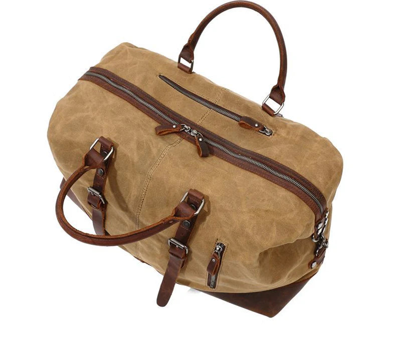 A large, khaki-coloured canvas crossbody luggage bag with multiple pockets and compartments for organised travel