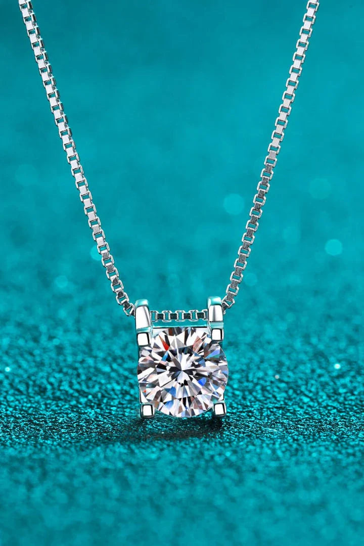 Closeup view of a sparkling 1 carat moissanite gemstone set in a rhodium-plated 925 sterling silver chain necklace