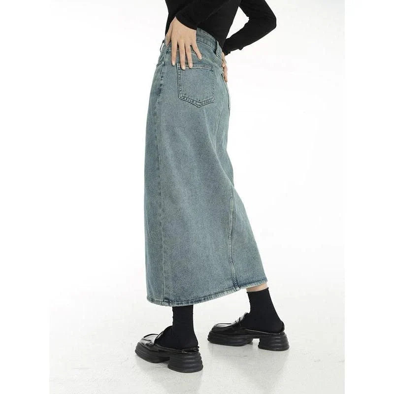 Chic vintage blue denim midi skirt with front slit, featuring a flattering A-line silhouette and stylish distressed details