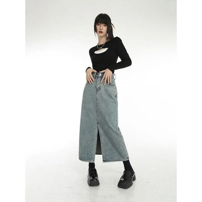 Chic vintage blue denim midi skirt with front slit, featuring a flattering A-line silhouette and stylish distressed details
