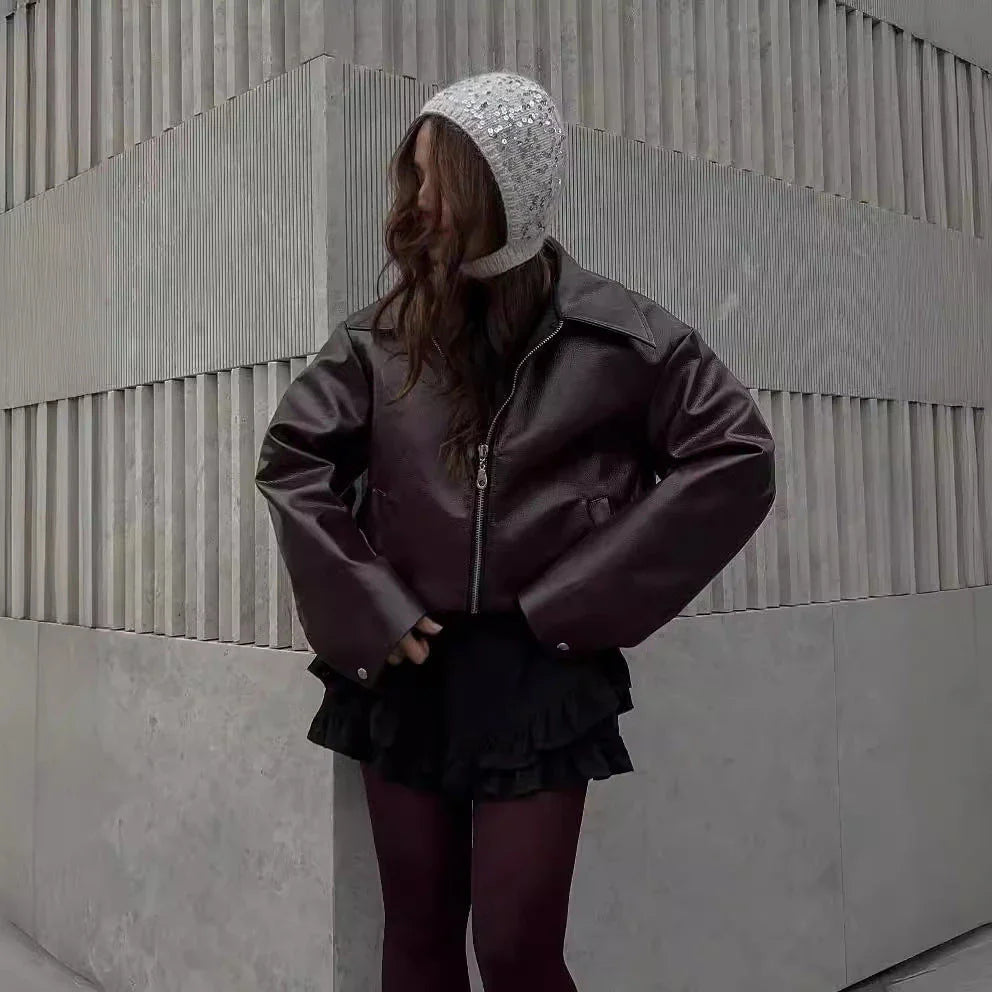 Fashionable faux leather jacket in burgundy and black colors, featuring a zipper closure and long sleeves for casual, versatile wear